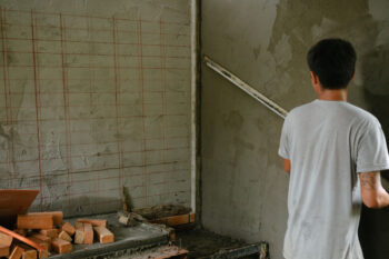 Man works in the room, makes repairs. Unfinished apartment interior. Repairs in the apartment.