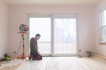 Man works in the room, makes repairs. Unfinished apartment interior. Repairs in the apartment.